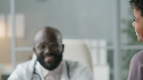 Afroamerikanischer-Kinderarzt-Im-Gespräch-Mit-Dem-Kind-Und-Seiner-Mutter-In-Der-Klinik